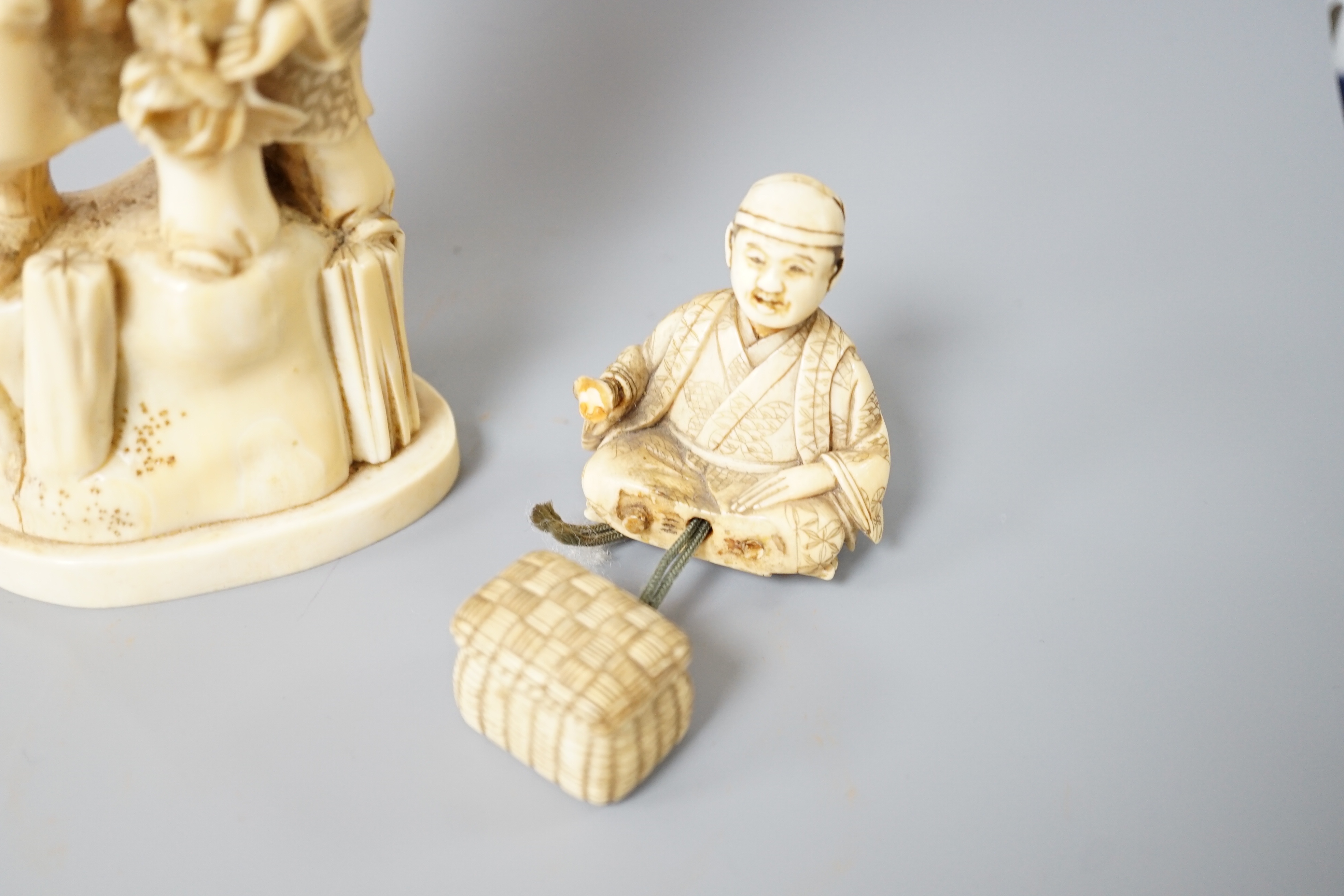 A 19th century Japanese marine ivory okimono of a bearded man and child together with a similar ivory okimono of a mask seller. Tallest 21cm